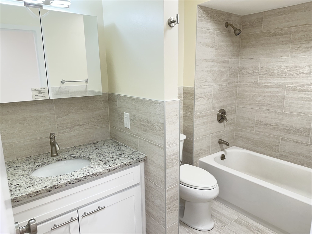 1004 Paradise Road, Unit 1K Swampscott, MA 01907 - Photo 20 of 37 a bathroom with a granite countertop sink a toilet and bathtub