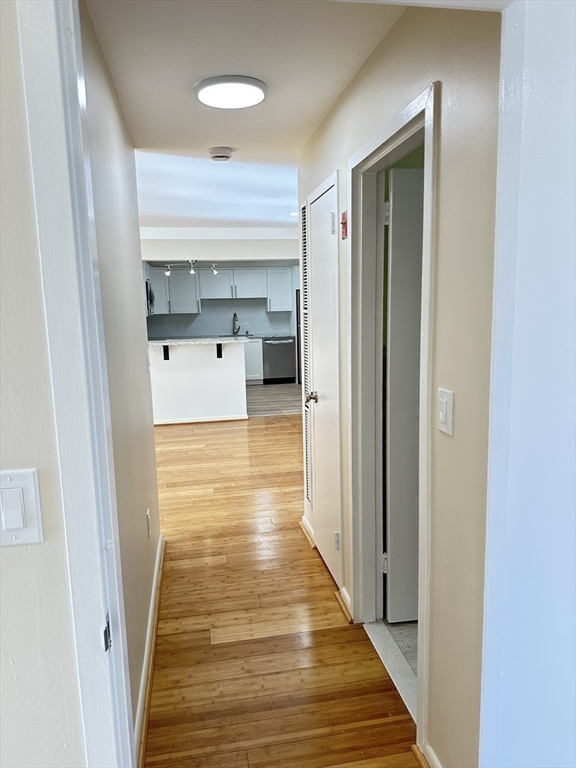 1004 Paradise Road, Unit 1K Swampscott, MA 01907 - Photo 22 of 37 a view of a hallway with wooden floor and staircase