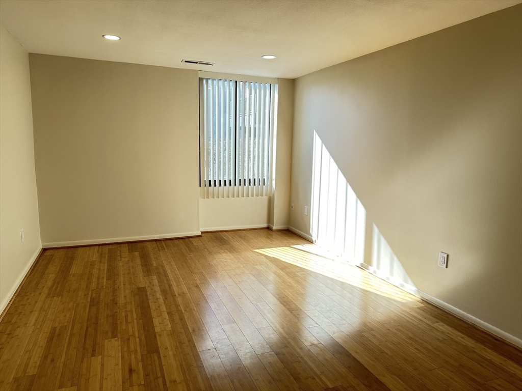 1004 Paradise Road, Unit 1K Swampscott, MA 01907 - Photo 23 of 37 a view of an empty room with wooden floor and a window