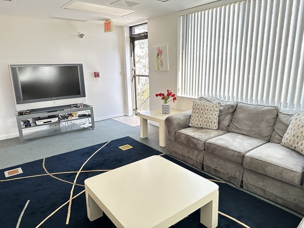 1004 Paradise Road, Unit 1K Swampscott, MA 01907 - Photo 32 of 37 a living room with furniture and a flat screen tv