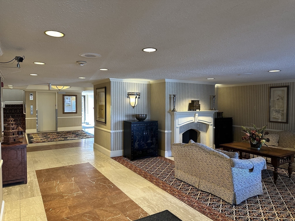 1004 Paradise Road, Unit 1K Swampscott, MA 01907 - Photo 4 of 37 a living room with furniture a large window and a fireplace