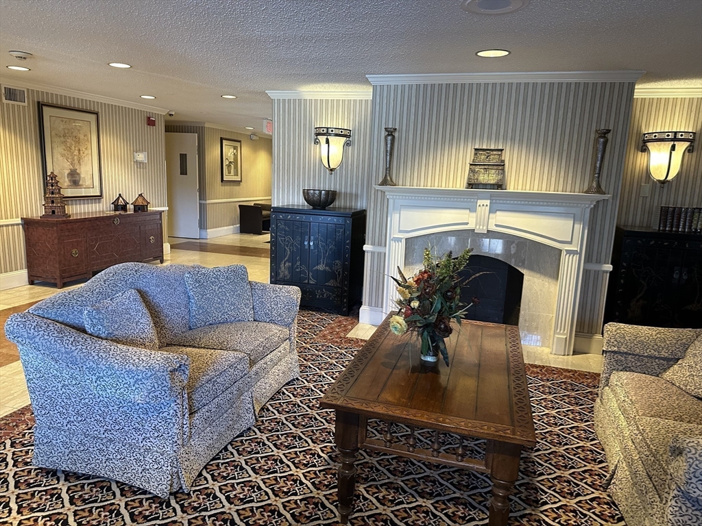 1004 Paradise Road, Unit 1K Swampscott, MA 01907 - Photo 5 of 37 a living room with furniture a fireplace a flat screen tv and windows