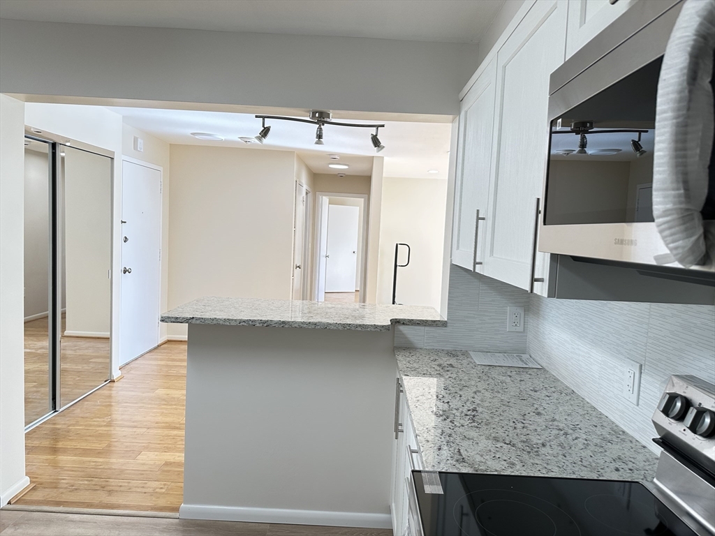 1004 Paradise Road, Unit 1K Swampscott, MA 01907 - Photo 9 of 37 a kitchen with granite countertop a sink and a stove
