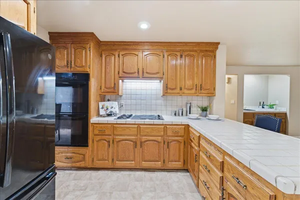 a kitchen with stainless steel appliances granite countertop a refrigerator and a stove