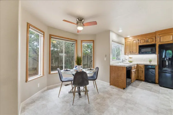 a dining room with furniture a large window and kitchen view