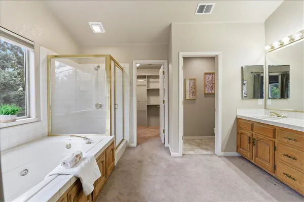 a spacious bathroom with a tub shower and sink