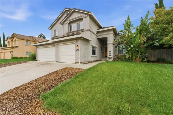 a front view of a house with a yard and garage