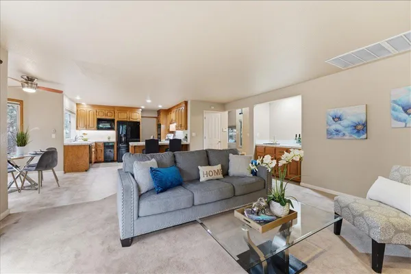 a living room with furniture dining area and a kitchen view