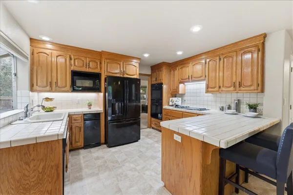 a kitchen with stainless steel appliances granite countertop a refrigerator sink stove and oven