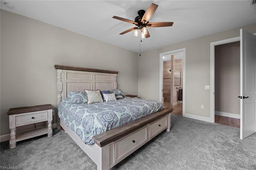 19648 Beechcrest Place Estero, FL 33928 - Photo 11 of 34 a bedroom with a bed and a chandelier