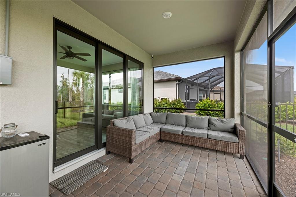 19648 Beechcrest Place Estero, FL 33928 - Photo 24 of 34 a living room with furniture and floor to ceiling windows