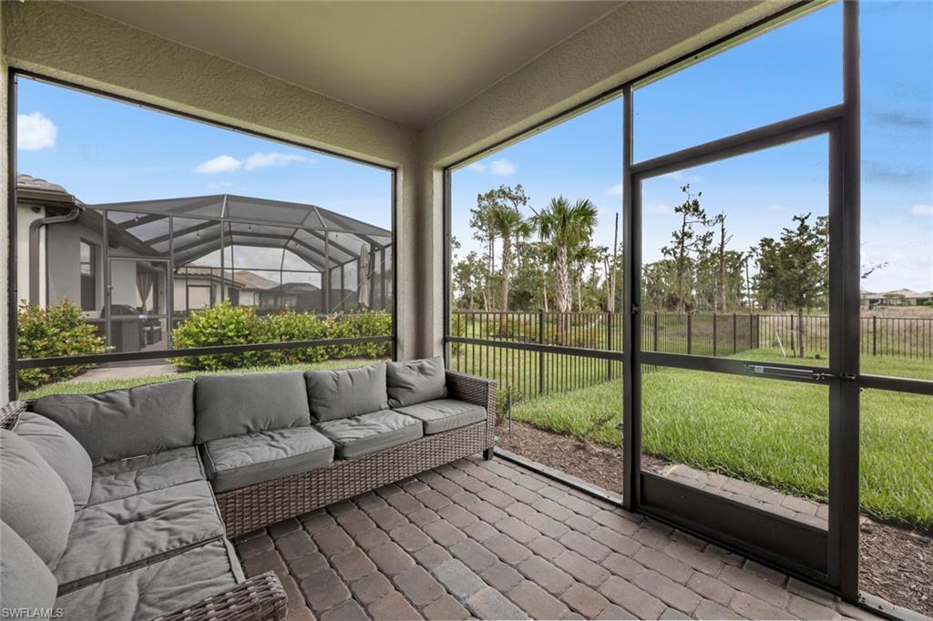 19648 Beechcrest Place Estero, FL 33928 - Photo 25 of 34 a living room with furniture and a floor to ceiling window