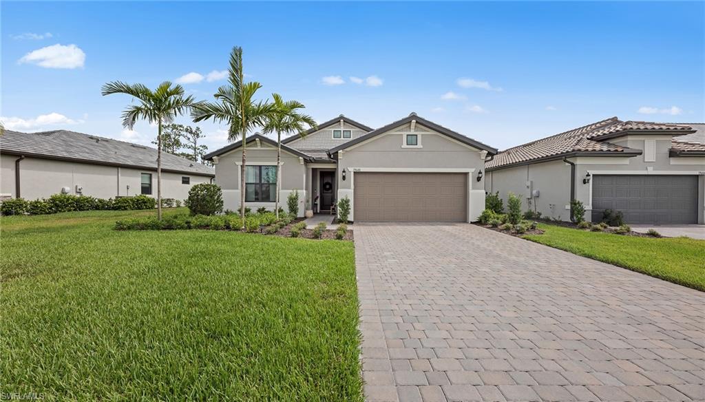 19648 Beechcrest Place Estero, FL 33928 - Photo 3 of 34 a front view of a house with a garden and plants