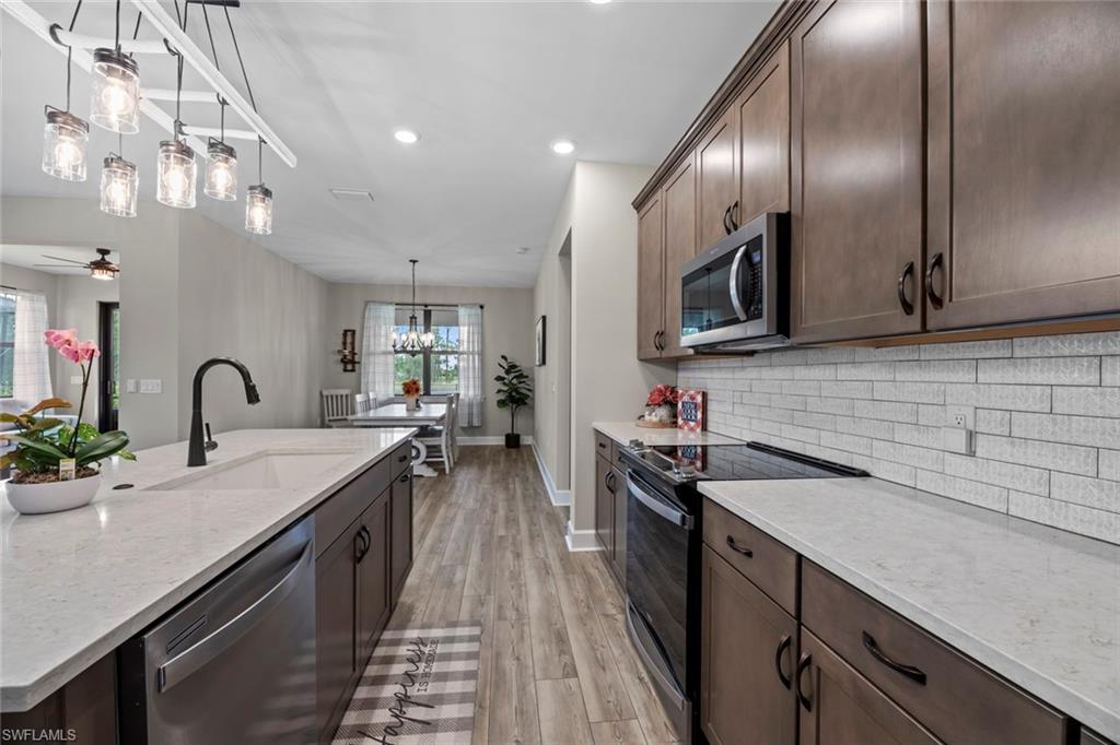 19648 Beechcrest Place Estero, FL 33928 - Photo 4 of 34 a kitchen with sink stove and cabinets