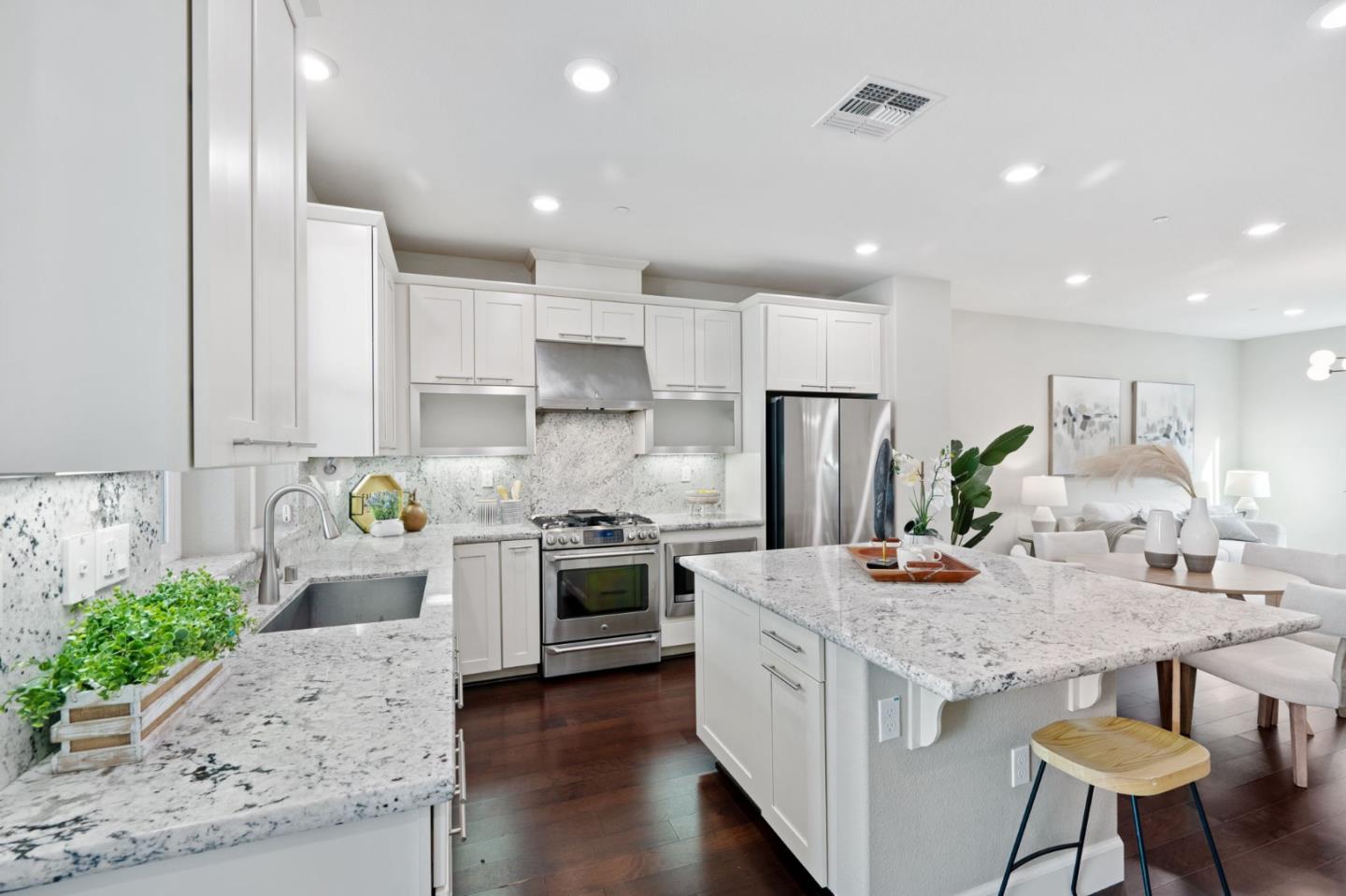 5977 Larkstone Loop San Jose, CA 95123 - Photo 18 of 63 a kitchen with kitchen island granite countertop a stove a sink a refrigerator and white cabinets