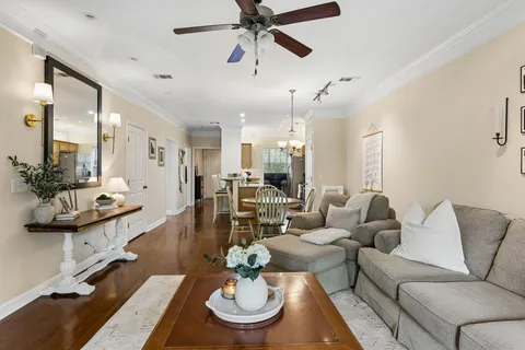a living room with furniture kitchen view and a chandelier