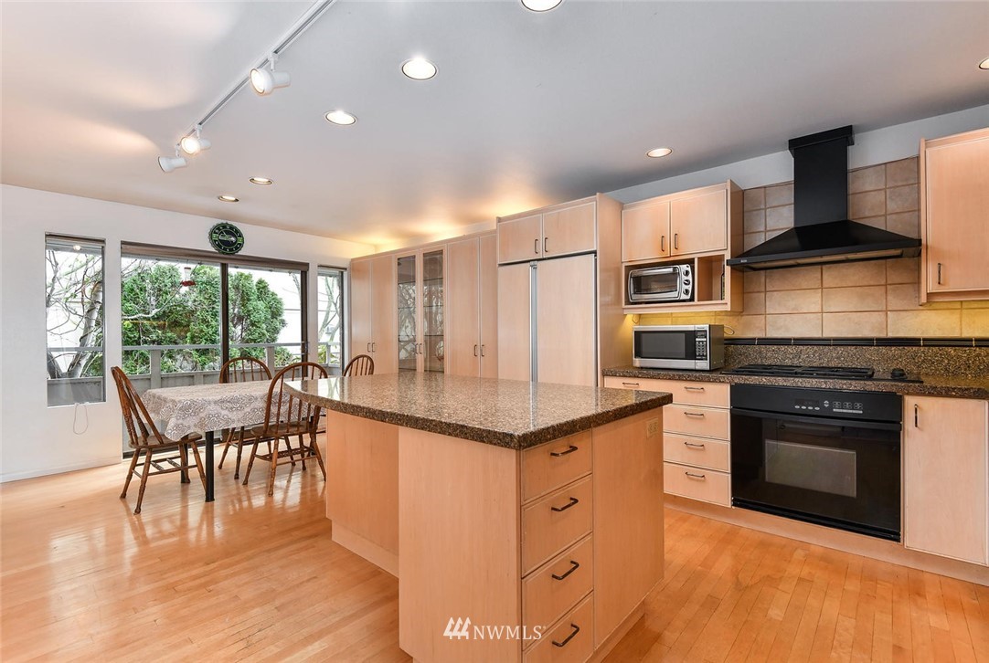 623 Main Street, Unit 3 Edmonds, WA 98020 - Photo 5 of 10 a kitchen with stainless steel appliances granite countertop a stove top oven a sink with dining table and chairs