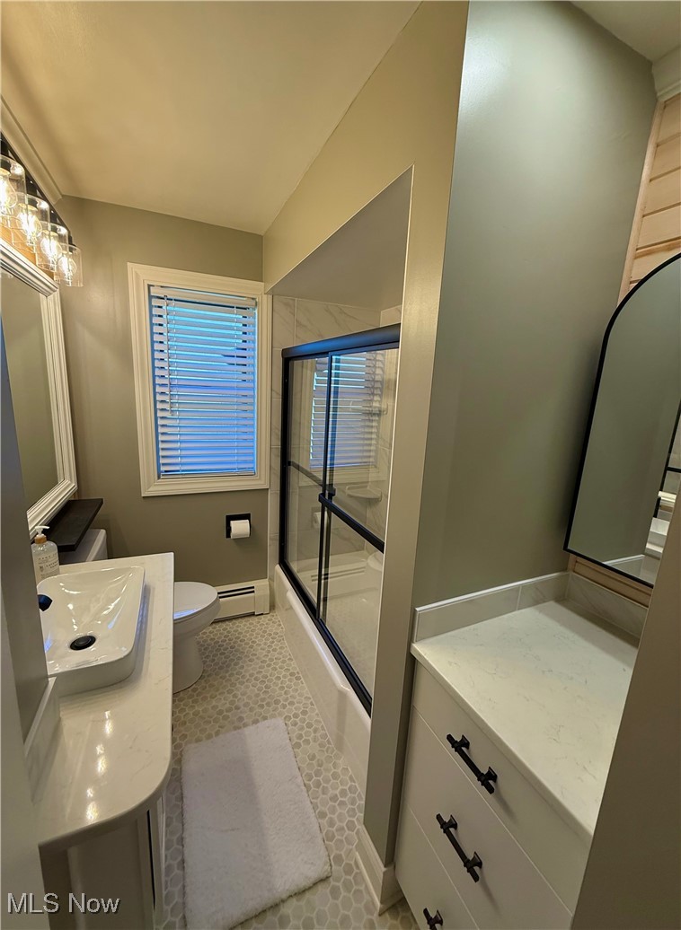 24836 Kennedy Ridge Road North Olmsted, OH 44070 - Photo 26 of 29 Bathroom featuring baseboard heating, vanity, toilet, tile patterned floors, and combined bath / shower with glass door