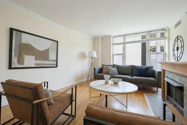 a living room with furniture a fireplace and a large window