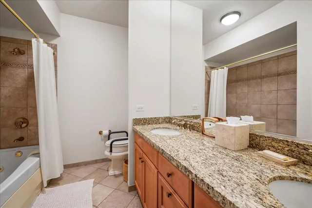 a bathroom with a granite countertop sink a toilet and shower