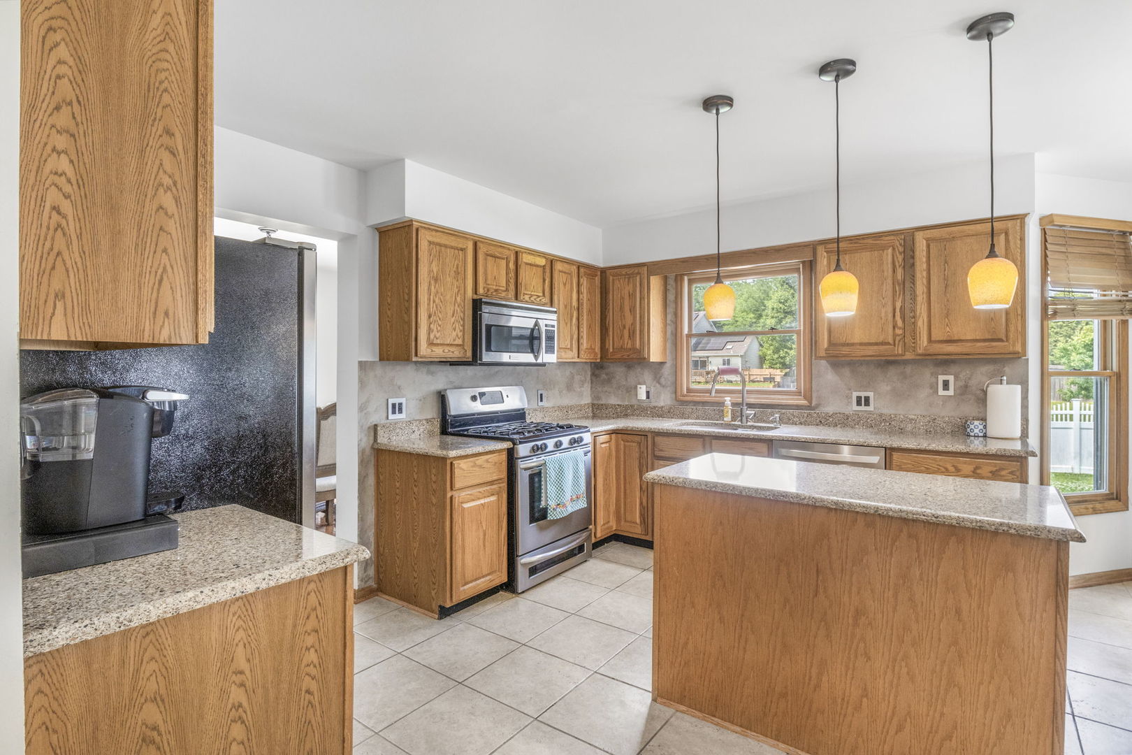5207 Sunmeadow Drive Plainfield, IL 60586 - Photo 14 of 32 a large kitchen with stainless steel appliances granite countertop a sink a stove and a wooden floors
