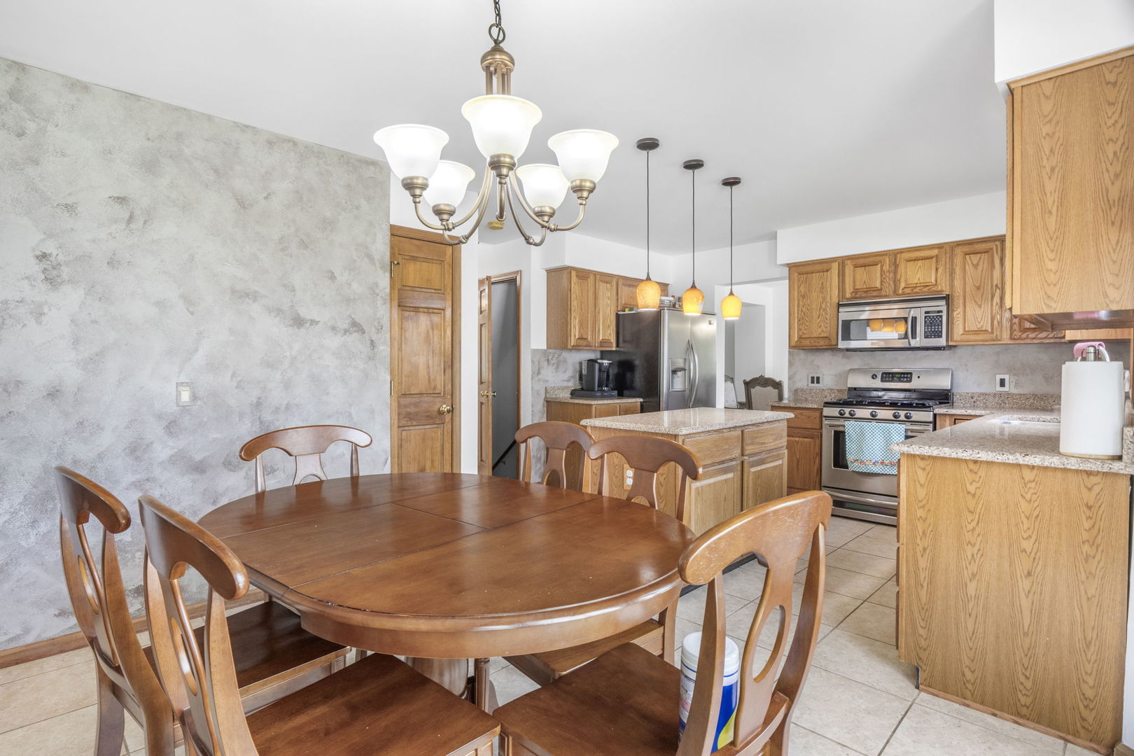 5207 Sunmeadow Drive Plainfield, IL 60586 - Photo 10 of 32 a dining room filled chandelier and kitchen view