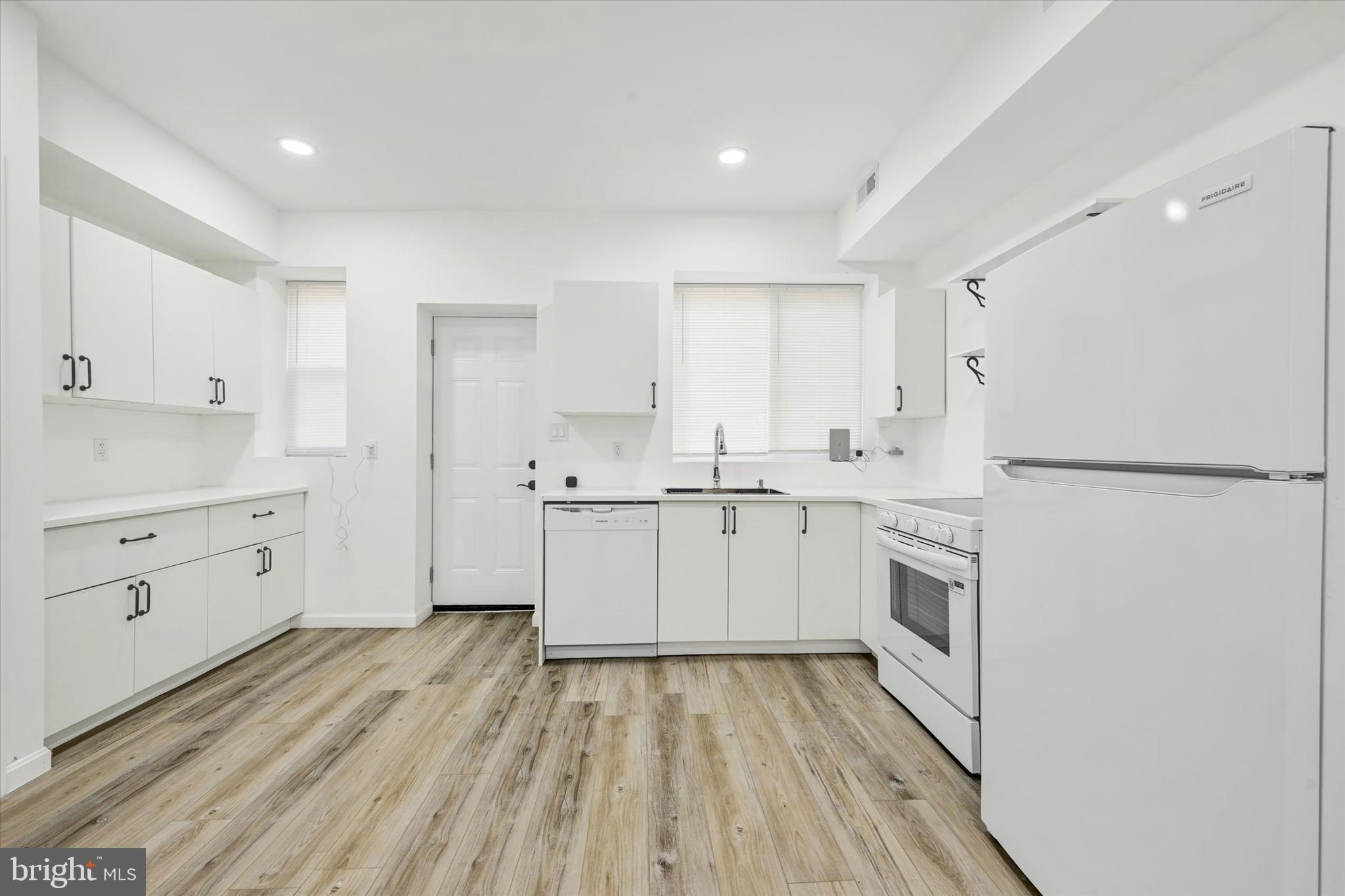 1604 Carswell Street Baltimore, MD 21218 - Photo 2 of 14 a kitchen with white cabinets and white appliances