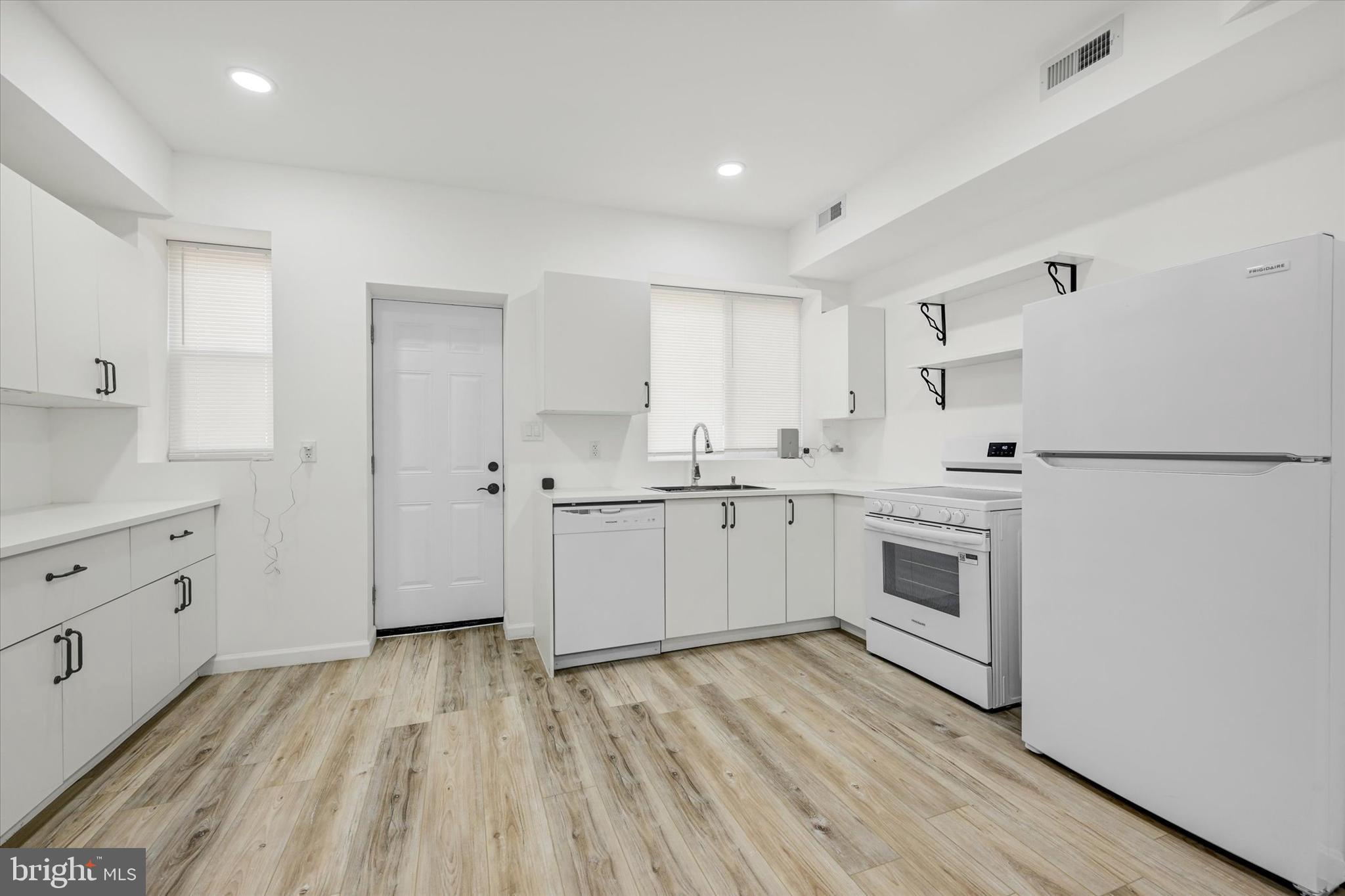 1604 Carswell Street Baltimore, MD 21218 - Photo 3 of 14 a kitchen with white cabinets white appliances and sink