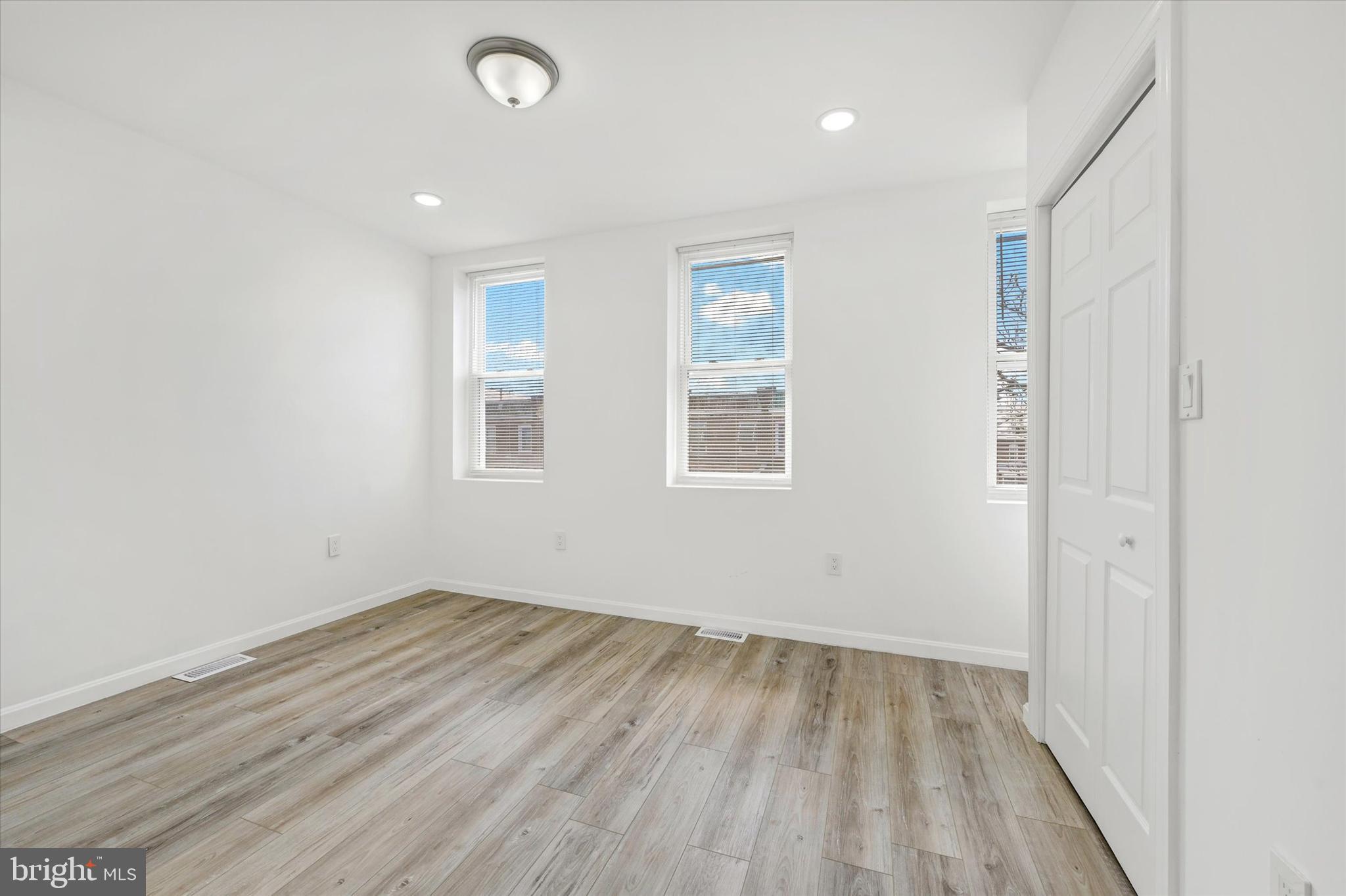 1604 Carswell Street Baltimore, MD 21218 - Photo 9 of 14 an empty room with wooden floor and windows