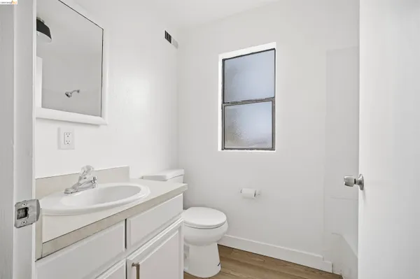 a bathroom with a toilet sink vanity and mirror