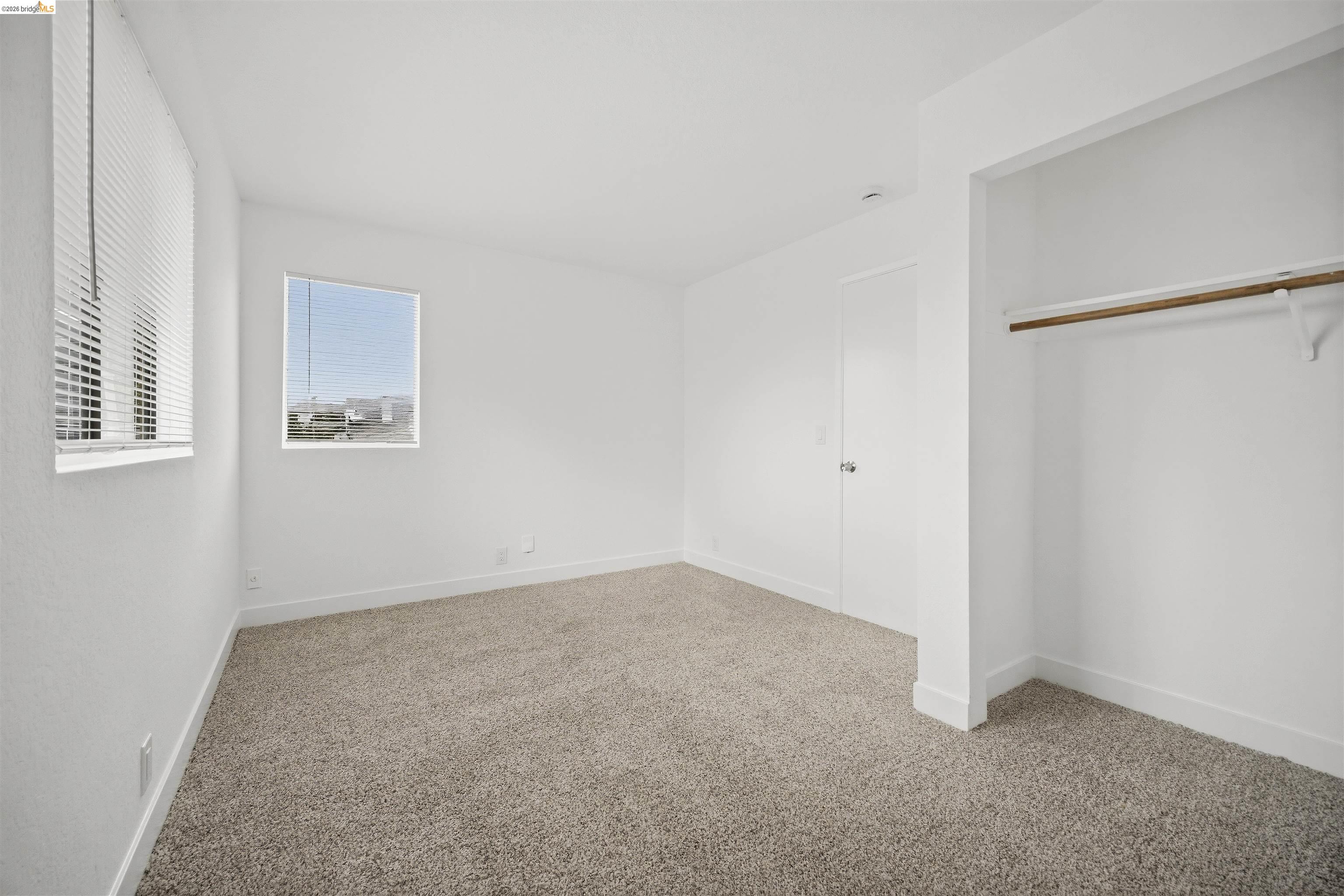 10933 Julius Street, Unit D Oakland, CA 94605 - Photo 16 of 28 Unfurnished bedroom featuring carpet and a closet