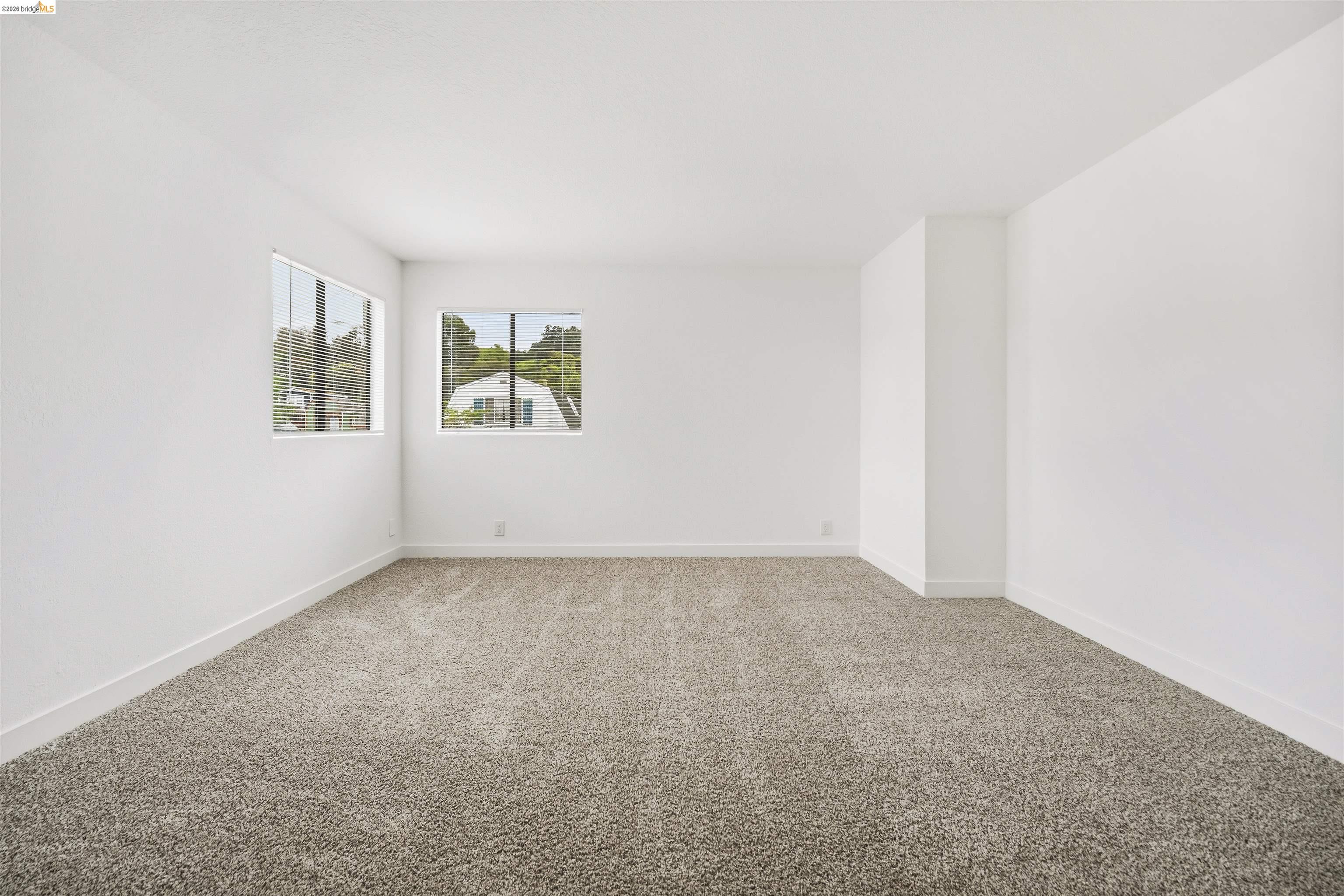 10933 Julius Street, Unit D Oakland, CA 94605 - Photo 18 of 28 Spare room featuring carpet flooring and baseboards