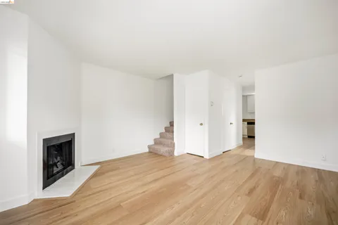 a view of empty room with wooden floor and fireplace