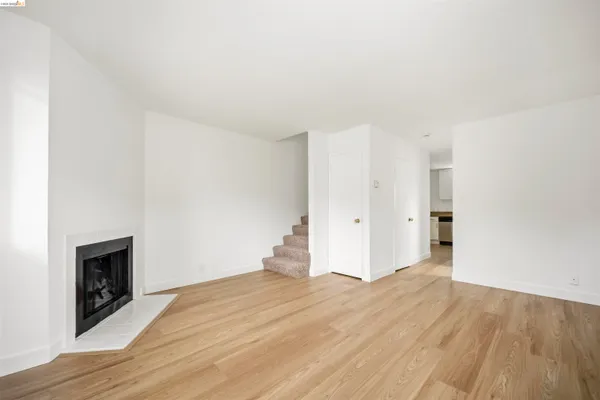 a view of empty room with wooden floor and fireplace