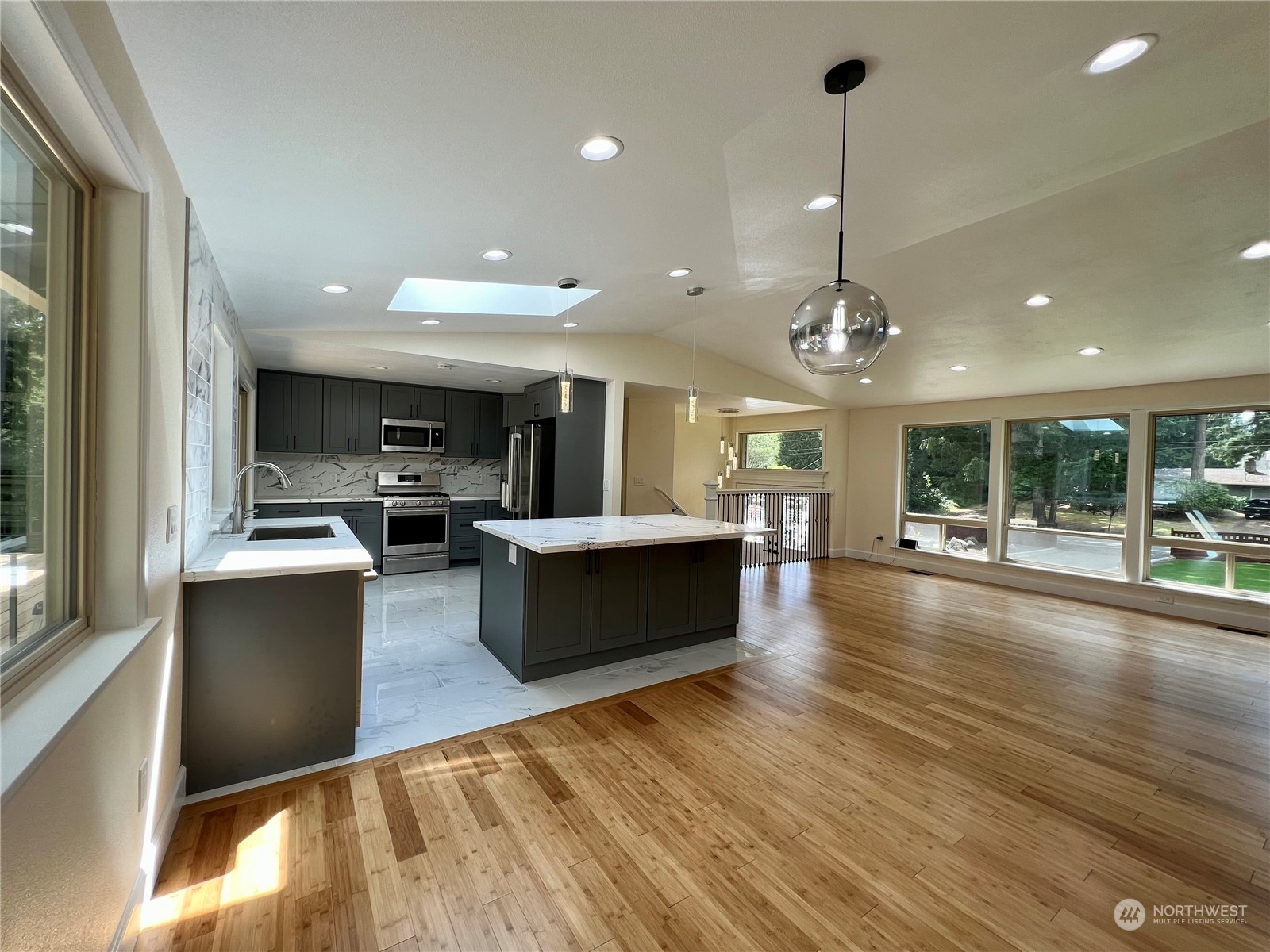 22925 49th Avenue Southeast Bothell, WA 98021 - Photo 7 of 40 a view of a kitchen with kitchen island a counter top space a sink stainless steel appliances and a large window