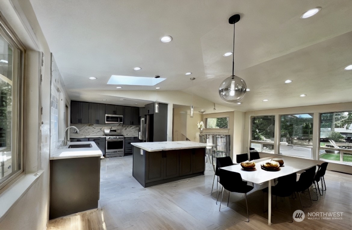 22925 49th Avenue Southeast Bothell, WA 98021 - Photo 8 of 40 a kitchen with stainless steel appliances kitchen island granite countertop a table and chairs in it