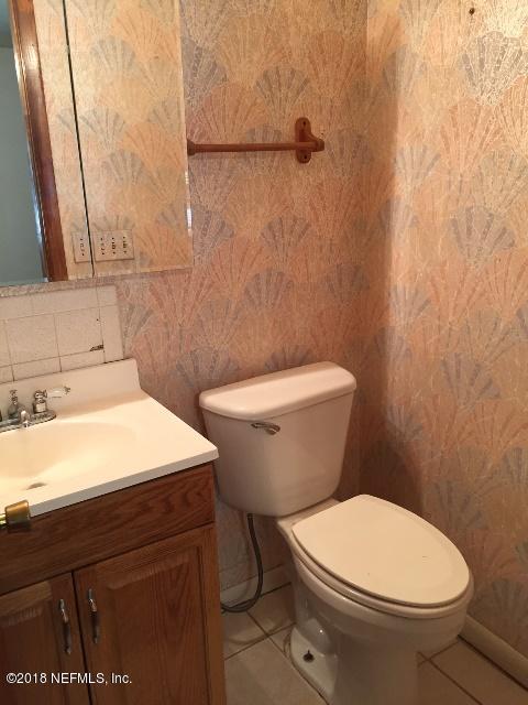 7391 Wheat Road Jacksonville, FL 32244 - Photo 14 of 26 a bathroom with a toilet a sink and a mirror