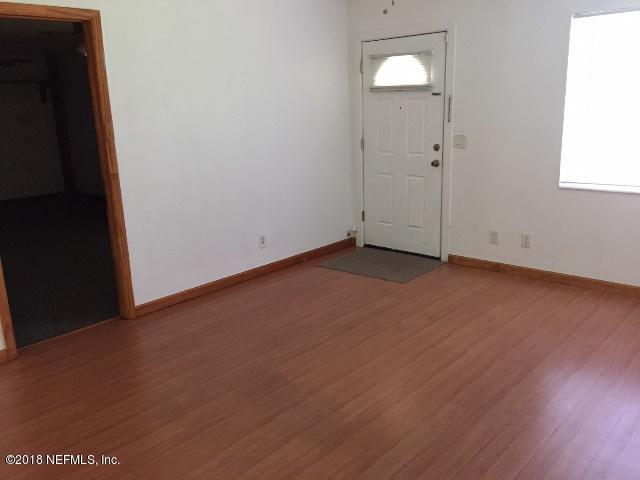 7391 Wheat Road Jacksonville, FL 32244 - Photo 6 of 26 an empty room with wooden floor and windows