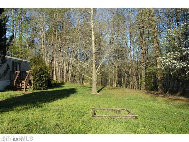 1203 Geeps Trail Road King, NC 27021 - Photo 3 of 16 Exterior Front. Front Yard Grass Area Behind Trees to Road