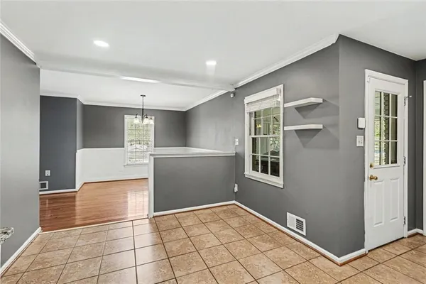 a view of hallway with a large window and wooden cabinets