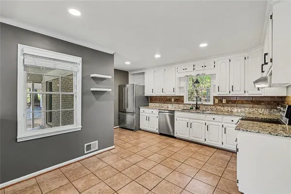 a kitchen with stainless steel appliances granite countertop a refrigerator sink and cabinets