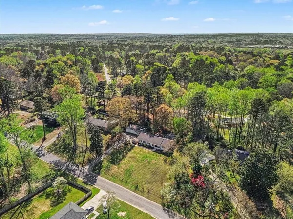an aerial view of residential houses with outdoor space and trees