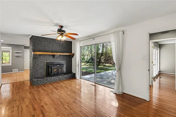 a living room with wooden floor and a fireplace