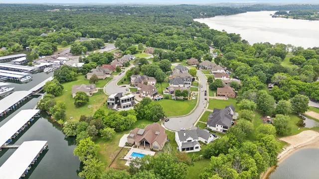 an aerial view of residential houses with outdoor space and trees