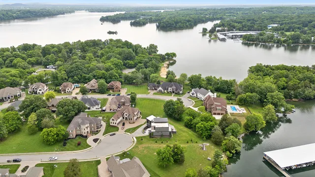 an aerial view of lake residential house with outdoor space and trees all around