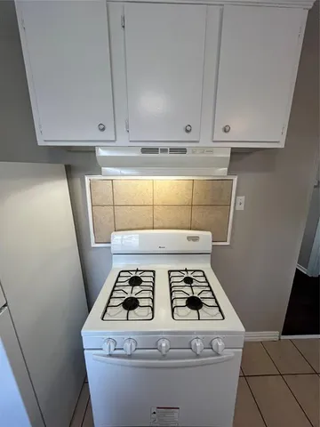 a stove top oven sitting inside of a kitchen