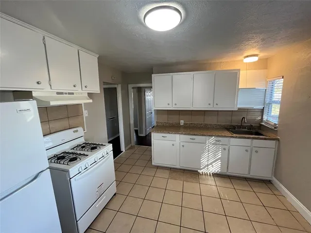a kitchen with a stove top oven and cabinets