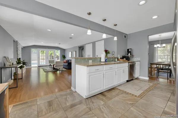 a kitchen with stainless steel appliances kitchen island a table and chairs in it