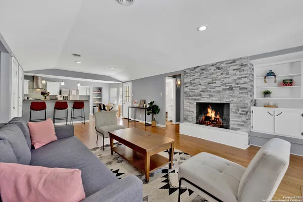 a kitchen with stainless steel appliances granite countertop a sink window and chairs