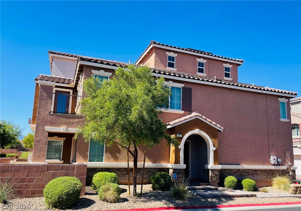9921 Sable Point Street Las Vegas, NV 89178 - Photo 1 of 43 An arched covered entry and stone accents define this multi-level home exterior.
